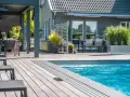 En avkopplande uteplats med pool, loungegrupp och matplats. Perfekt utedusch inspiration för sommaren.