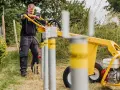 Man använder en stolpjärnmaskin för att slå ner stolpar, liknande de man kan hitta som markskruv biltema.