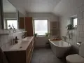 Modernt badrum med dubbla handfat, fristående badkar och vitt kakel. Perfekt för dig som vill renovera badrum.