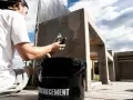 Man applicerar microcement utomhus på en betongkonstruktion. En hink med "Microcement" syns i förgrunden.
