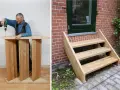 Man bygga trappa utomhus. En färdigbyggd trätrappa leder upp till en dörr.