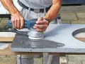 Man slipar betonggolv med en maskin.