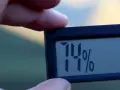 En digital hygrometer visar 74% luftfuktighet inomhus.