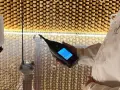 Person i laboratorierock mäter ljudnivån från en luftrenare utan filter i ett ekofritt rum.
