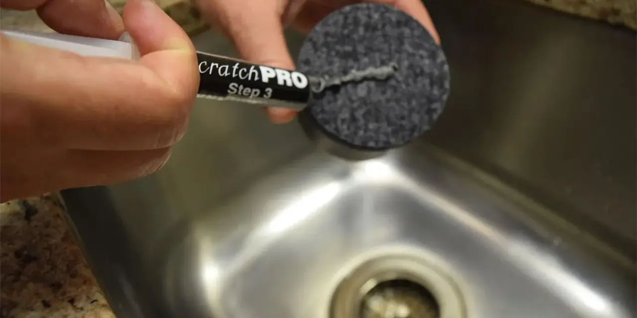 Händer använder en produkt för att ta bort repor på rostfritt stål.