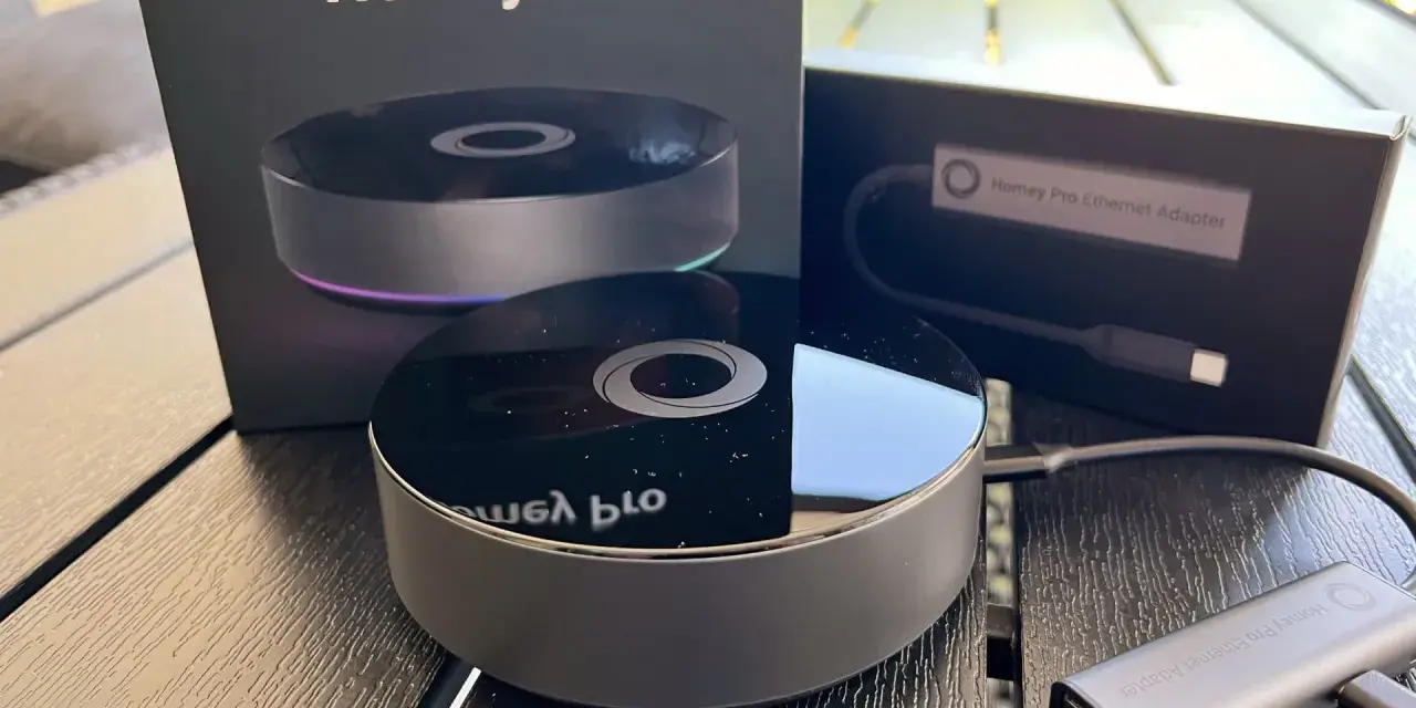 Homey Pro 2019 och Ethernet-adapter på ett träbord. En smart hem-hub för ett bekvämt hem.