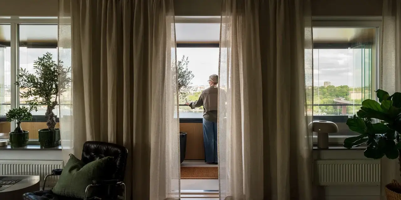 En person står vid balkongdörren och njuter av utsikten, redo att kyla ner sovrummet.