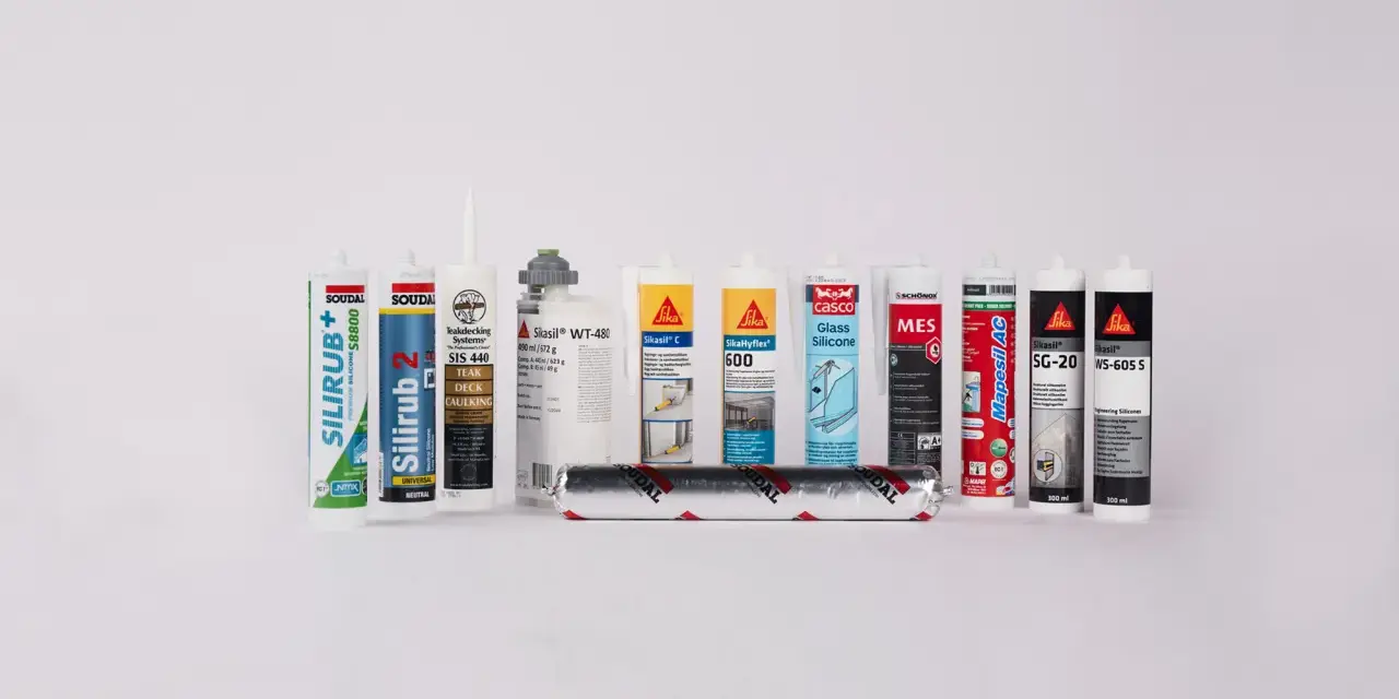 En rad tuber med silikonfog utomhus, inklusive märken som Soudal, Sika och Casco.