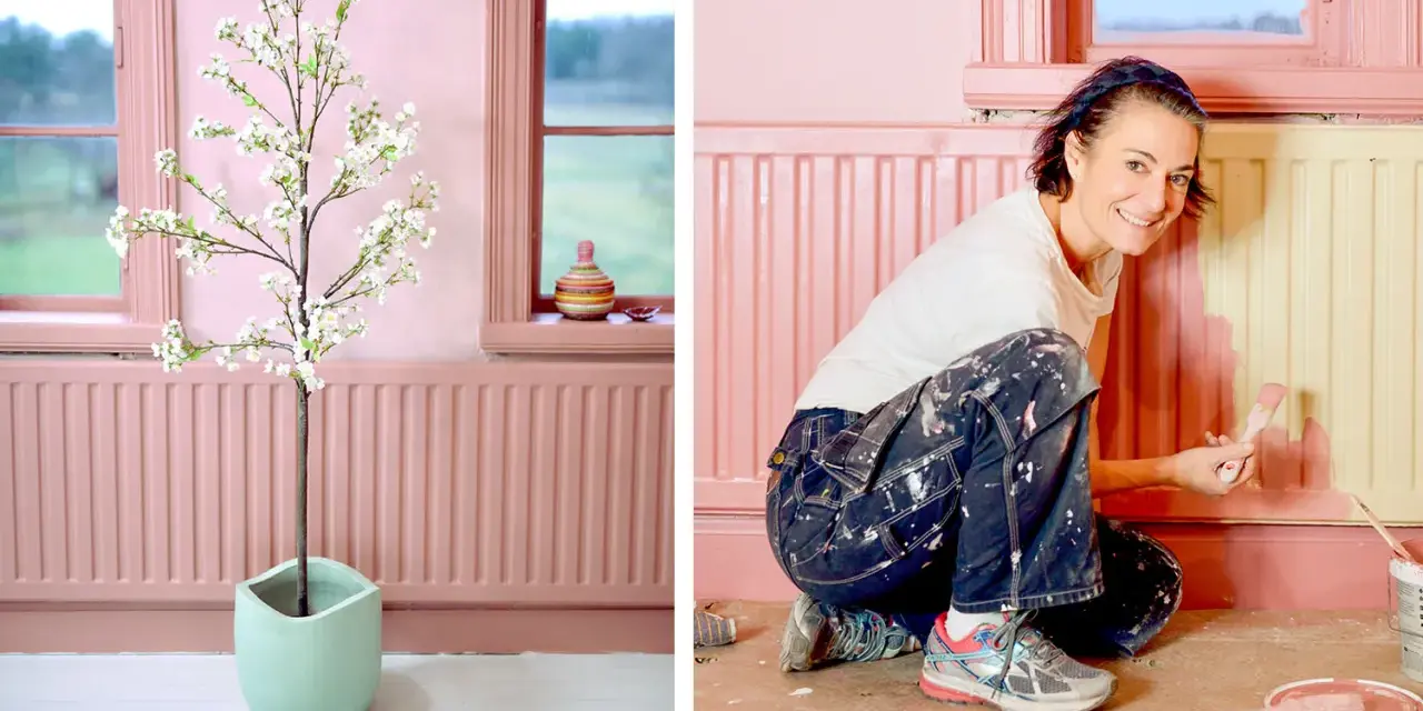 Kvinna målar element i rosa. En konstgjord blommande körsbärsgren står i en ljusgrön kruka.
