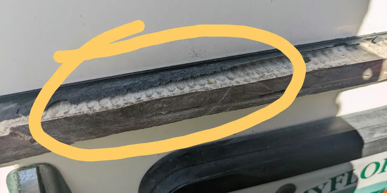 Detaljerad bild som visar hur man kan ta bort silikon med aceton. En gul cirkel markerar ett område med gammal silikon som behöver tas bort.