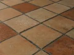 Rödbruna och beige klinkerplattor i ett rutmönster. Tänk att måla klinkergolv för att ge det nytt liv!