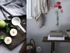 Äpplen och mjöl på en träskärbräda, redo att baka. Bredvid en vas med vallmo och en stickad tröja. En idyllisk scen som får det att **betsa furu** i köket.