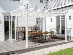 En vit pergola med tygtak skapar en mysig uteplats med matbord och stolar. Perfekt för att bygga pergola med plasttak för soliga dagar.