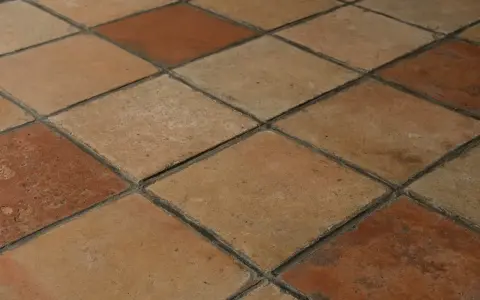 Rödbruna och beige klinkerplattor i ett rutmönster. Tänk att måla klinkergolv för att ge det nytt liv!