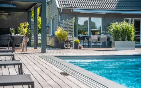En avkopplande uteplats med pool, loungegrupp och matplats. Perfekt utedusch inspiration för sommaren.