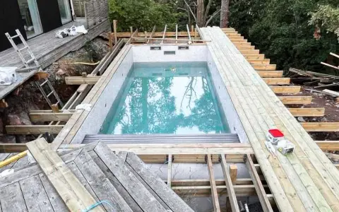 Byggnation av pool med tillhörande trädäck och trappa. Ger bastu inspiration för framtida projekt.
