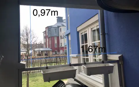 Mått för att bygga vindskydd: 0,97m och 1,67m. Utsikt över radhus och trädgård.