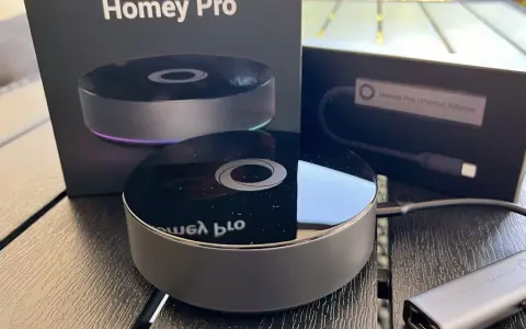 Homey Pro 2019 och Ethernet-adapter på ett träbord. En smart hem-hub för ett bekvämt hem.