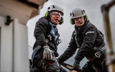 Två byggnadsarbetare med 3M Peltor WS Alert X-hörselskydd på sig, redo för dagens utmaningar.