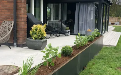 En modern odlingslåda på altanen ger plats för grönska.
