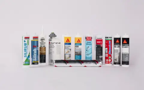 En rad tuber med silikonfog utomhus, inklusive märken som Soudal, Sika och Casco.