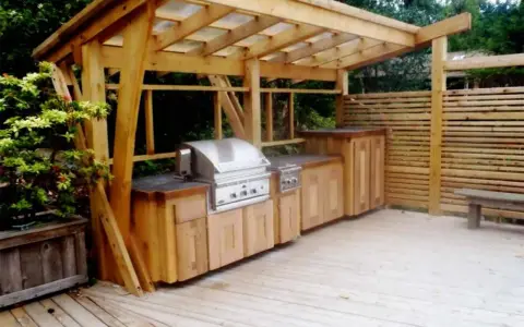 En vacker trägrillplats med inbyggd grill och förvaring. Perfekt grillplats inspiration för din uteplats.