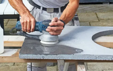 Man slipar betonggolv med en maskin.