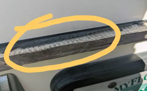 Detaljerad bild som visar hur man kan ta bort silikon med aceton. En gul cirkel markerar ett område med gammal silikon som behöver tas bort.