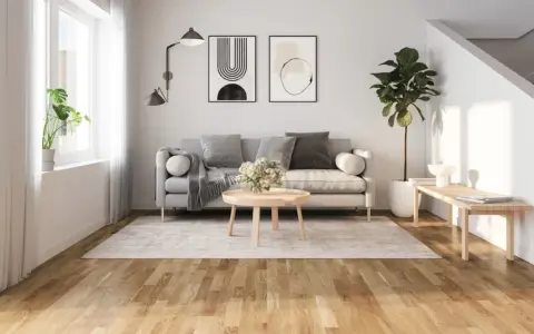 Ljust vardagsrum med grå soffa, träbord och en vacker trägolv. Perfekt golv inspiration för ett modernt hem.