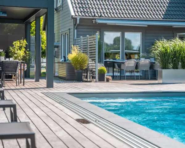 En avkopplande uteplats med pool, loungegrupp och matplats. Perfekt utedusch inspiration för sommaren.