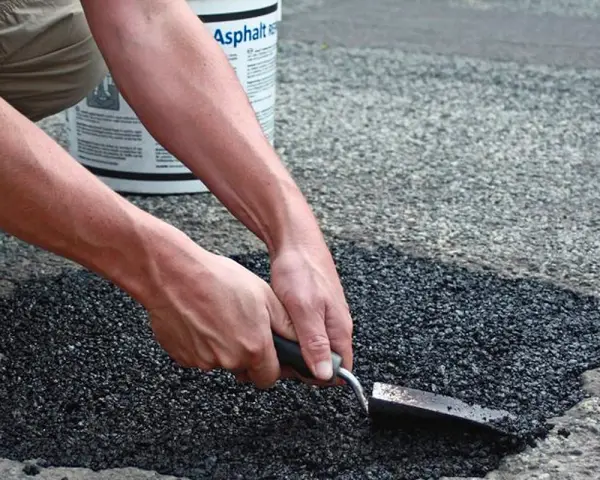 Händer som reparerar asfalt med en spade. En hink med "Asphalt" syns i bakgrunden.