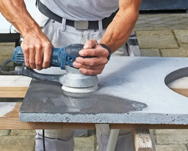 Man slipar betonggolv med en maskin.