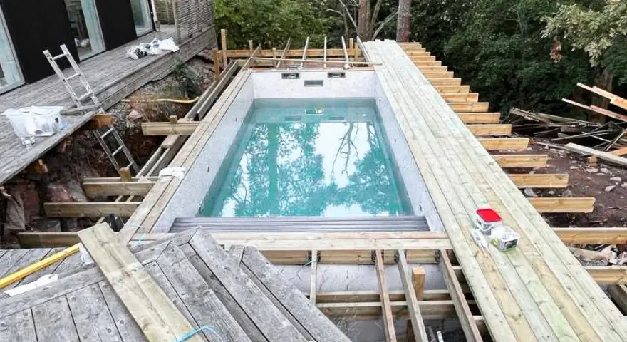 Byggnation av pool med tillhörande trädäck och trappa. Ger bastu inspiration för framtida projekt.