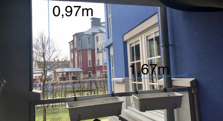 Mått för att bygga vindskydd: 0,97m och 1,67m. Utsikt över radhus och trädgård.
