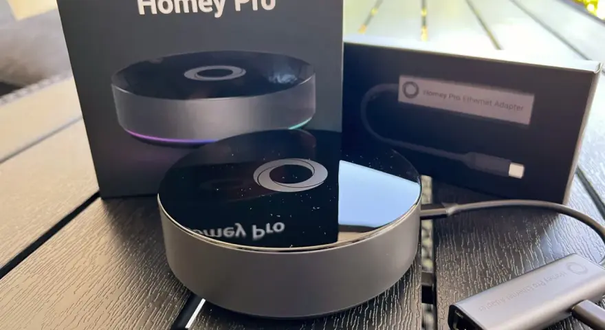 Homey Pro 2019 och Ethernet-adapter på ett träbord. En smart hem-hub för ett bekvämt hem.
