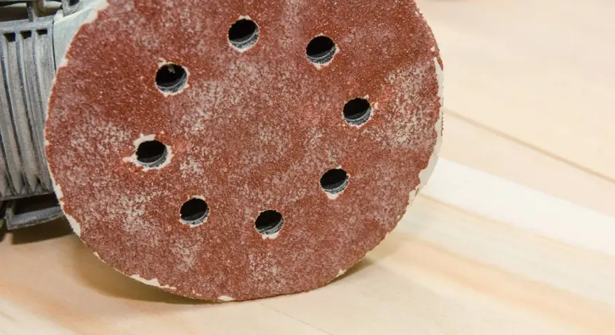 Rund slippapper med hål för dammutsug. Kornstorlek avgör hur fint resultatet blir.