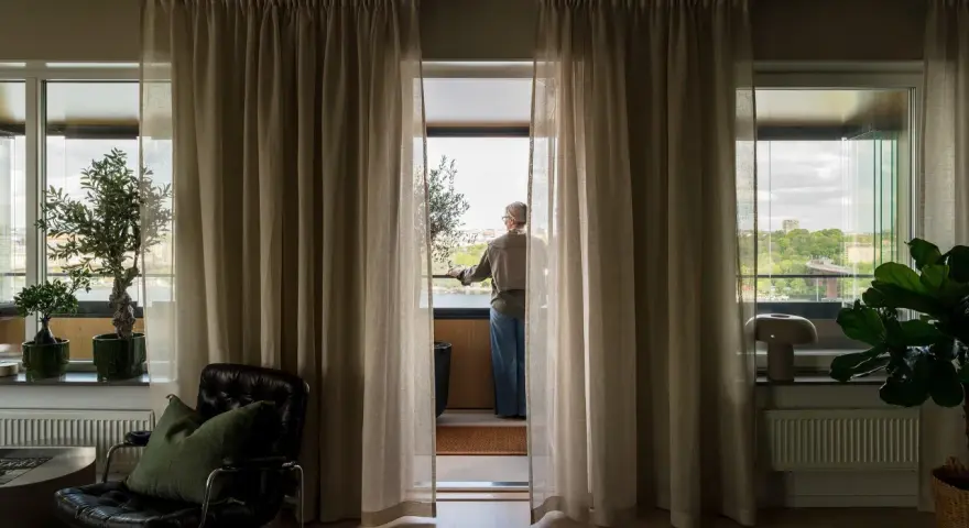 En person står vid balkongdörren och njuter av utsikten, redo att kyla ner sovrummet.
