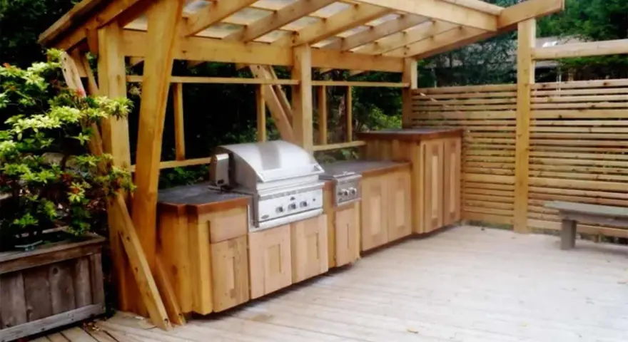 En vacker trägrillplats med inbyggd grill och förvaring. Perfekt grillplats inspiration för din uteplats.