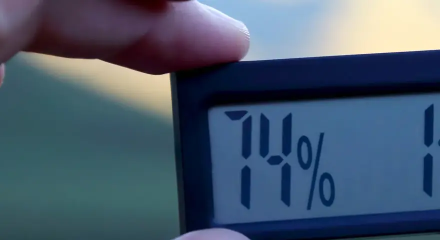 En digital hygrometer visar 74% luftfuktighet inomhus.