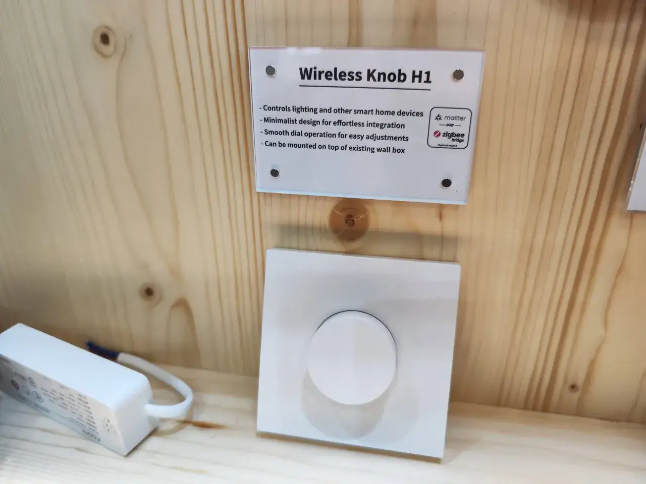 En vit trådlös vridknapp för smarta hem, en del av aqara homey-systemet, med en skylt som beskriver dess funktioner.