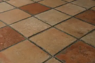 Rödbruna och beige klinkerplattor i ett rutmönster. Tänk att måla klinkergolv för att ge det nytt liv!