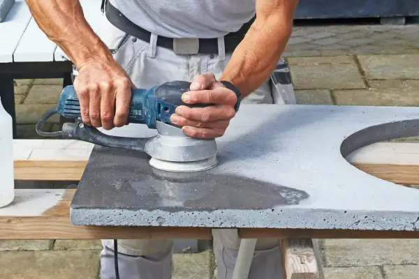 Man slipar betonggolv med en maskin.